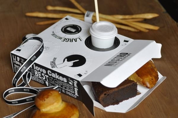 A pastry box with built-in coffee holder