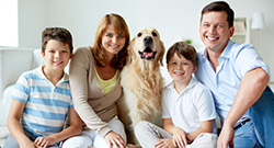 Portrait of happy family with fluffy Labrador having rest at home