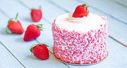 Strawberry cake with white cream on wooden background