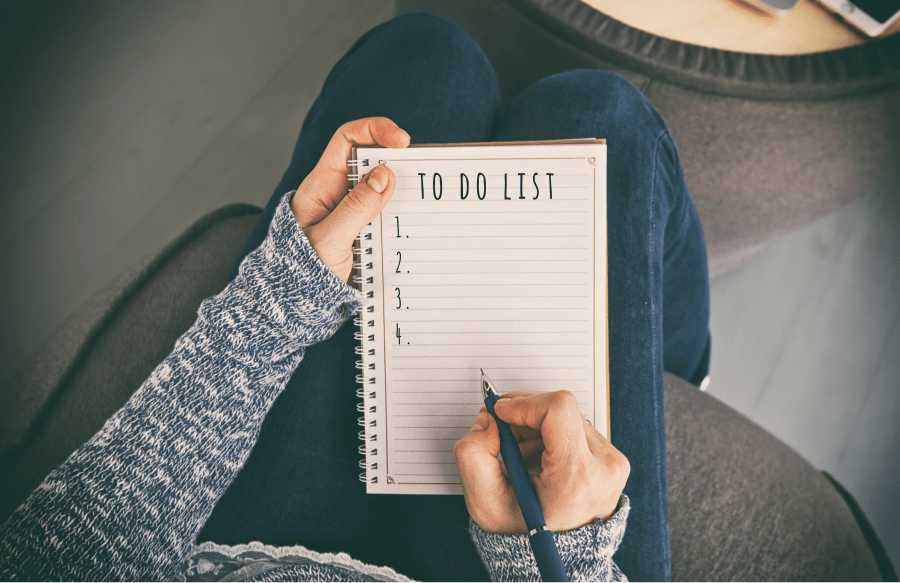 a woman writing tasks in a to-do list.