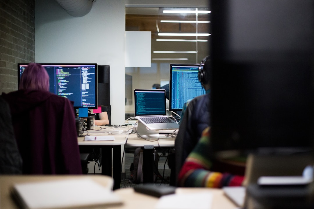 Office scene with individuals engaged in using computers, emphasizing the application of account planning software.